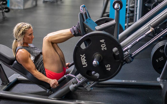 strong girl performing leg press at gym, home gym, strength training with weights, to gain muscle. Strong quads on leg day